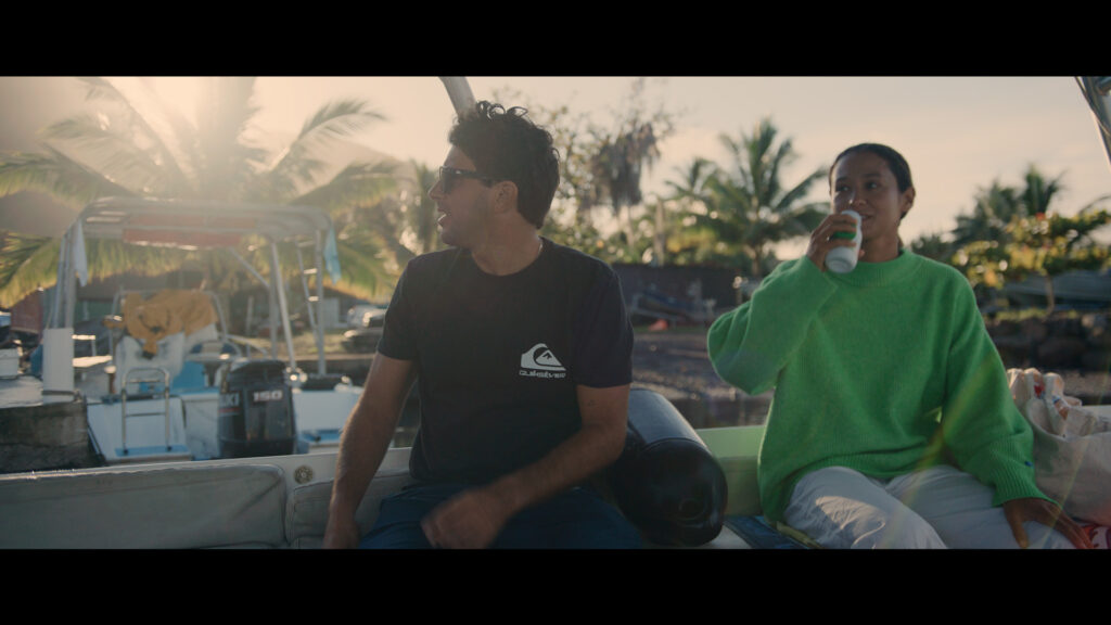 Two people are sitting on a boat at sunset, with ZEISS equipment visible next to them.