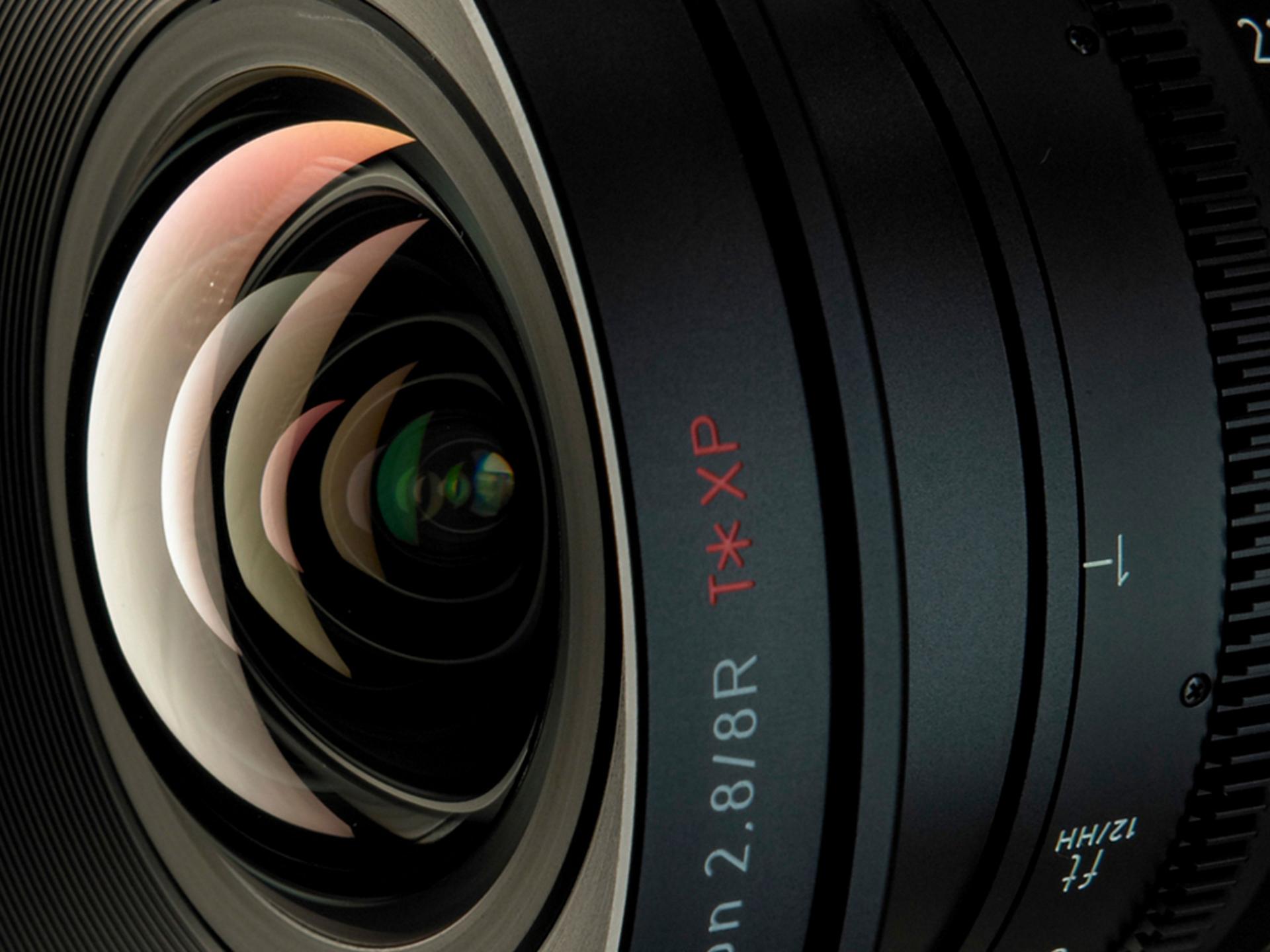 Close-up view of a ZEISS camera lens showcasing detailed glass elements and engraved technical specifications.