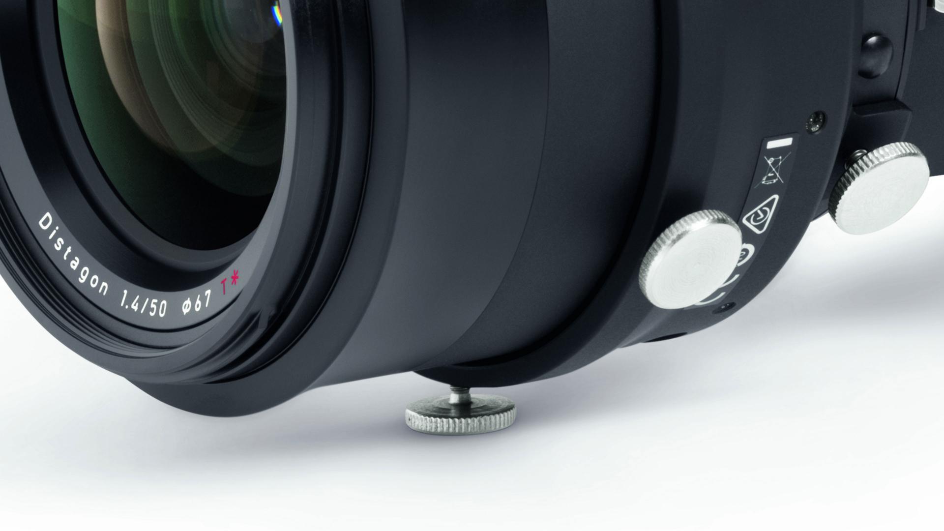 Close-up of a ZEISS Distagon 1.4/50 camera lens showing control dials and lens mount screws.