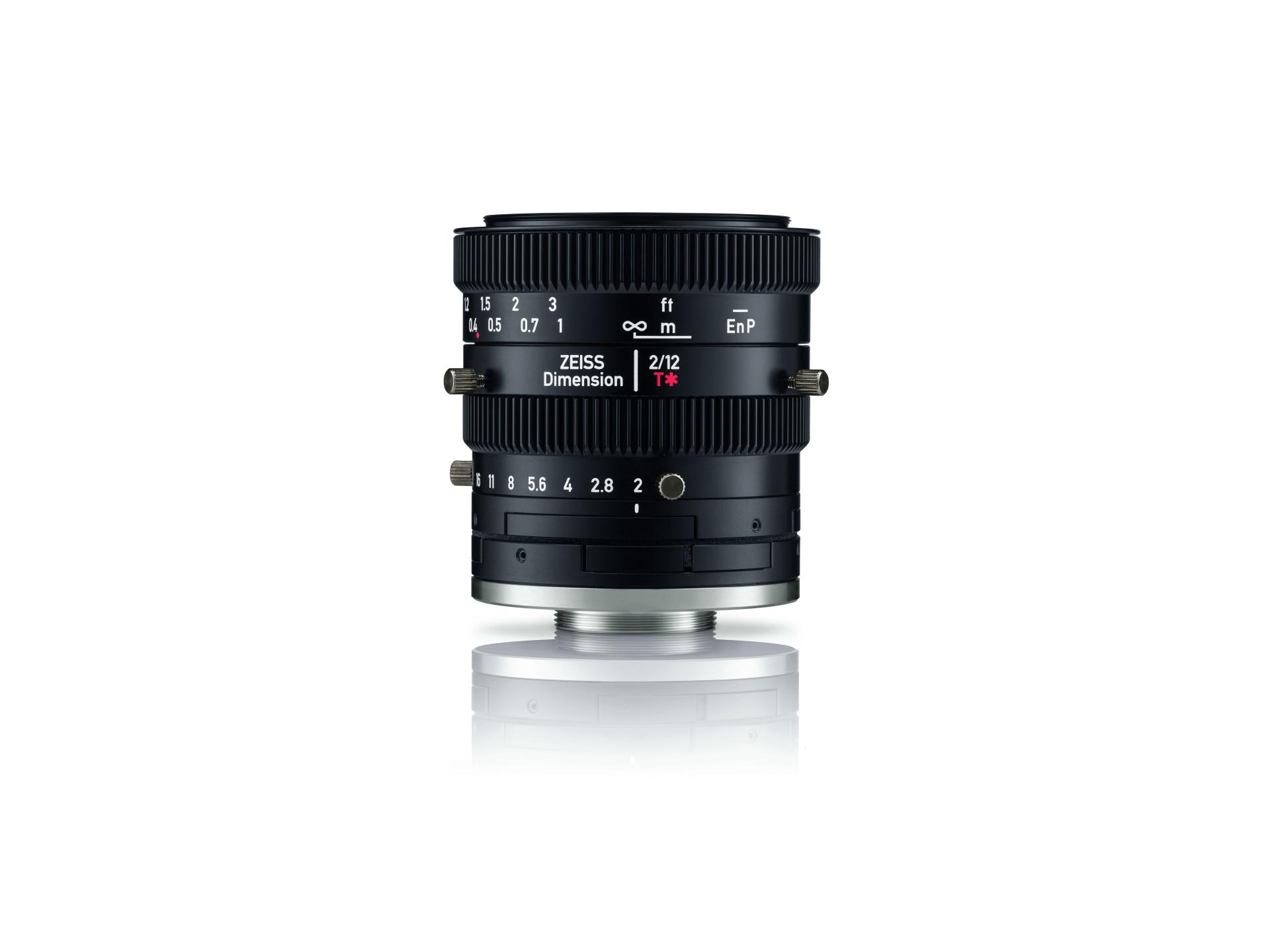 Close-up of a ZEISS Dimension 2/72 T* industrial camera lens standing upright on a white surface.