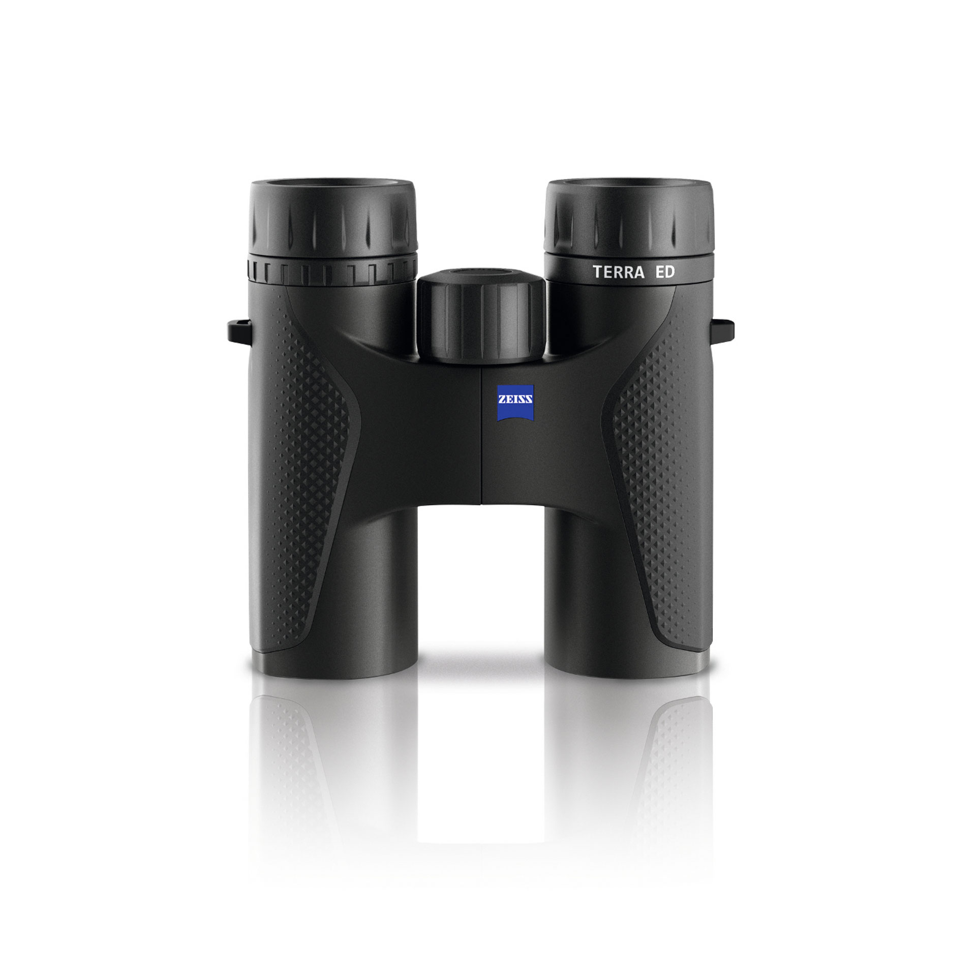 Black ZEISS TERRA ED binoculars with textured grips and central focusing wheel, shown from the front on a white reflective surface.