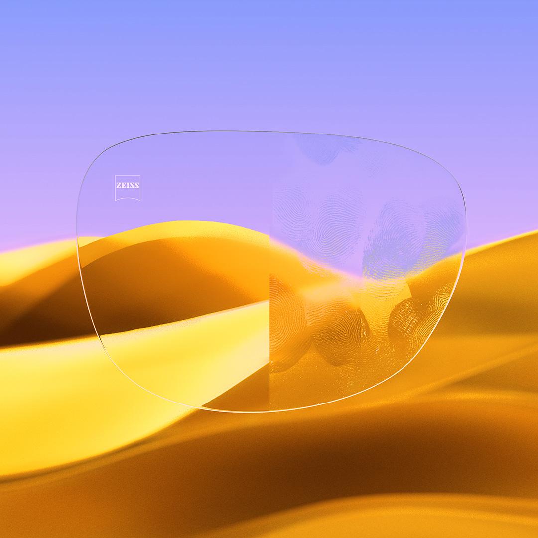 Lente per occhiali divisa, con un lato con trattamento ZEISS DuraVision Gold UV chiaro e pulito, e l&apos;altro lato con impronte.