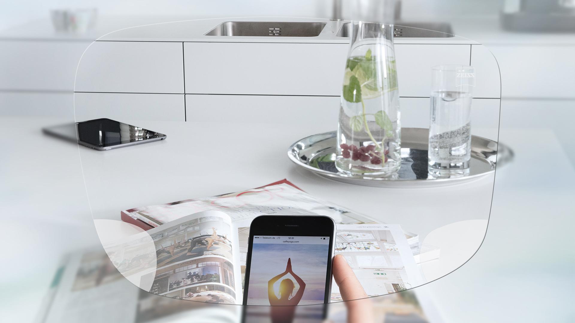 View through ZEISS EnergizeMe Single Vision Spectacle Lens at smartphone screen and organised kitchen table