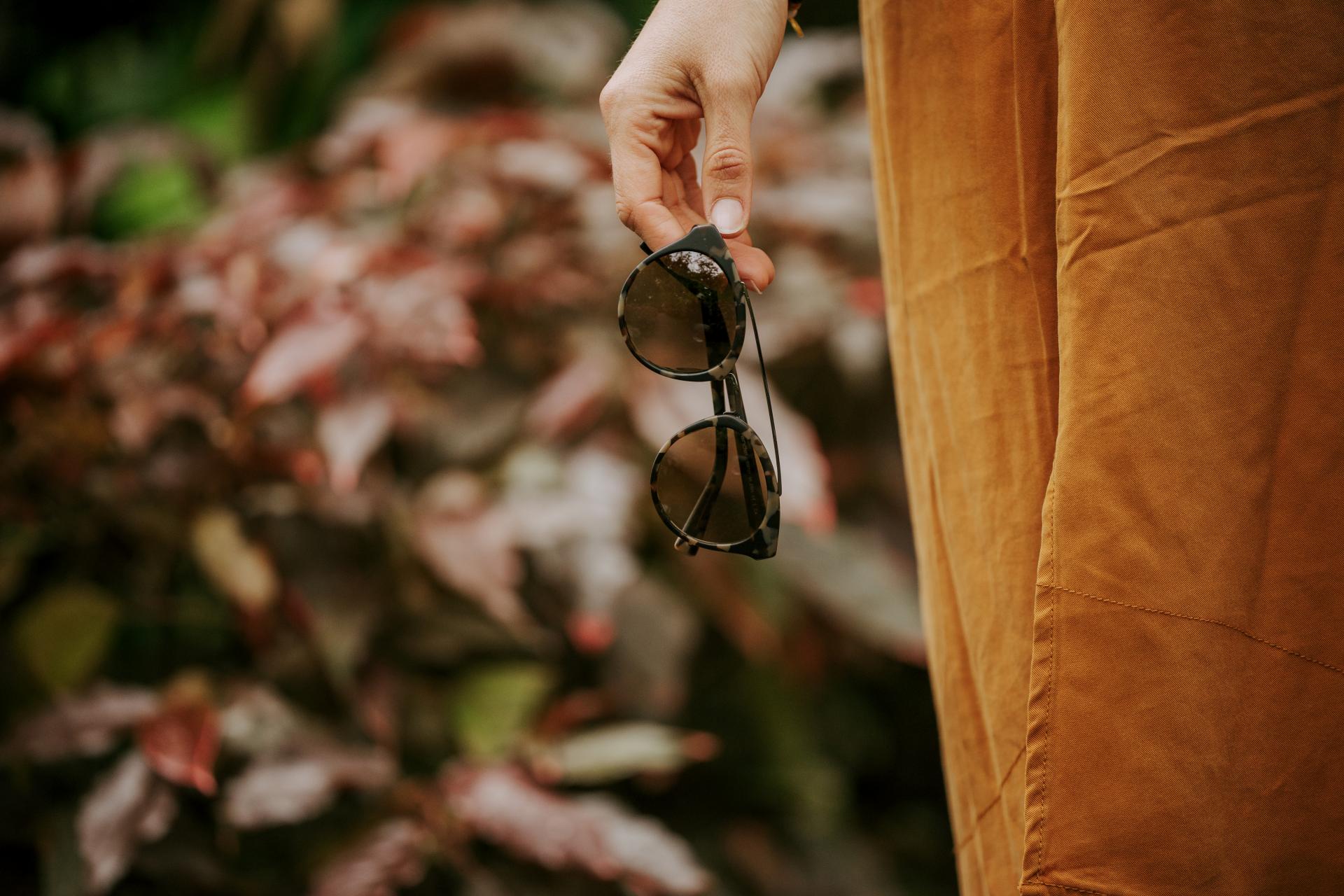 Occhiali da sole in mano ad una persona