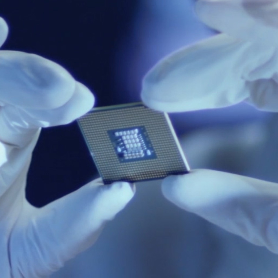 Un&apos;immagine di un microchip tenuto da una persona con i guanti da laboratorio. 