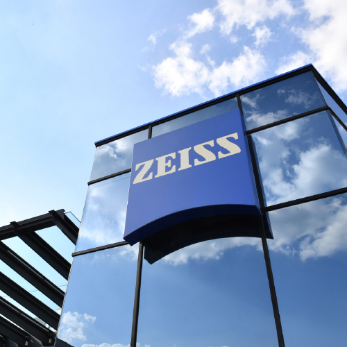 Un&apos;immagine di un moderno edificio in vetro con un enorme logo ZEISS. 