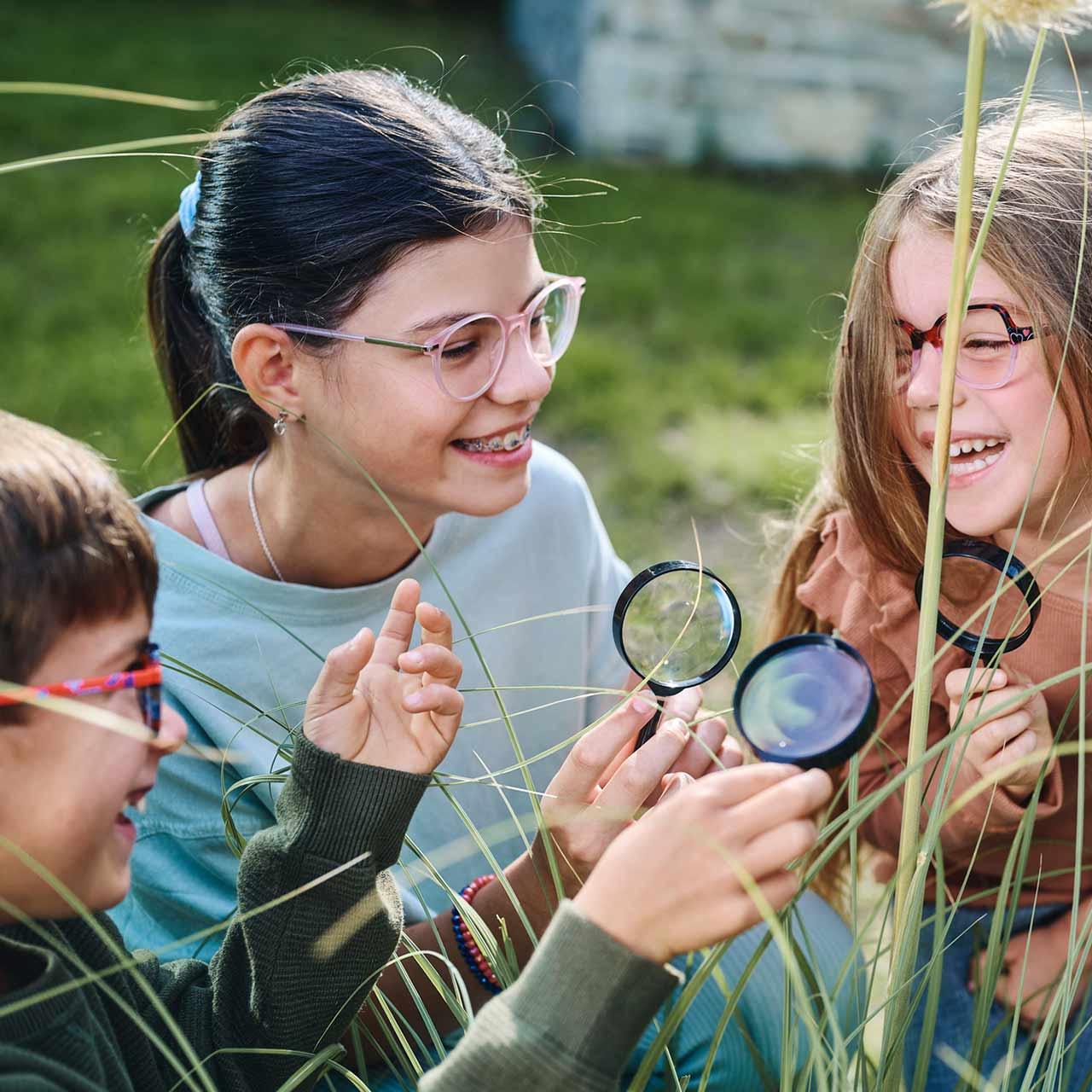Un gruppo di bambini con occhiali e lenti a contatto che gioca e ride all&apos;aperto