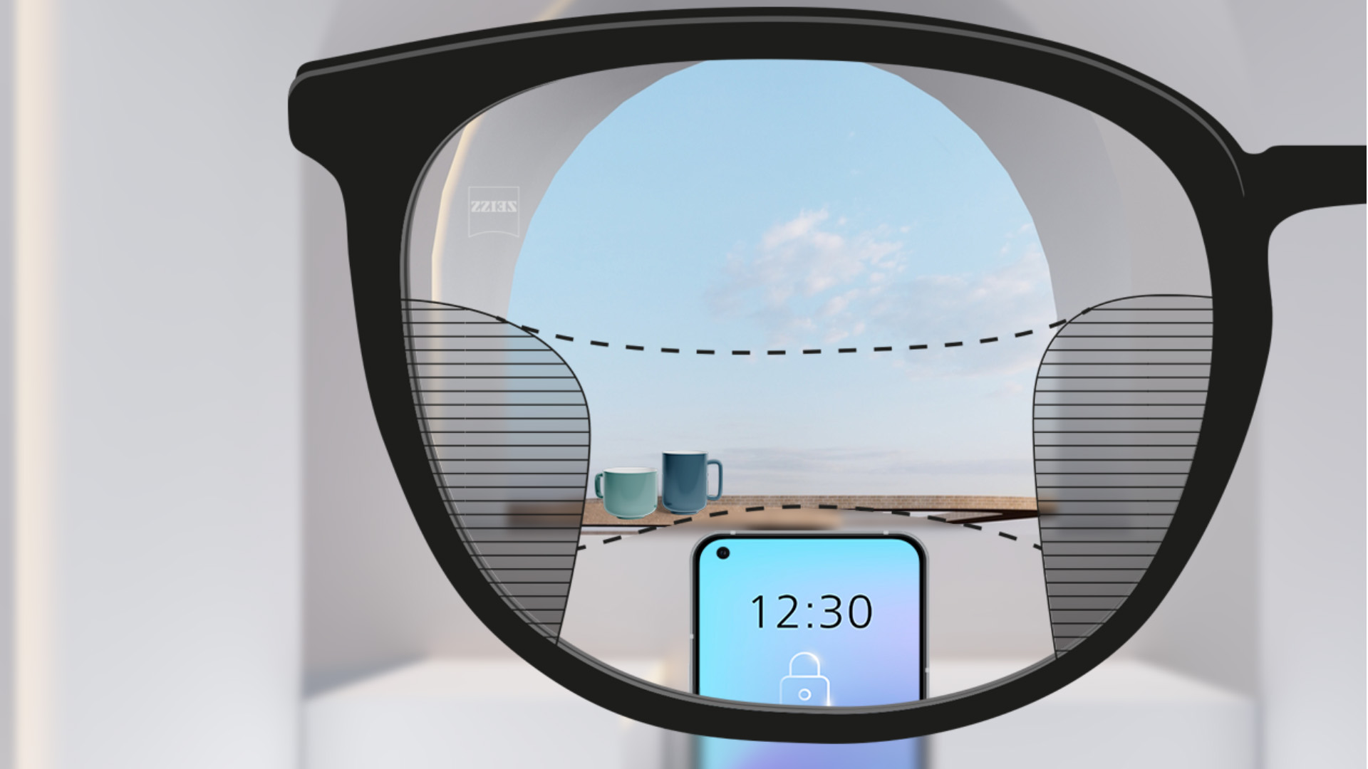 Immagine del punto di visione attraverso lenti Progressive ZEISS SmartLife con uno smartphone e tazze sullo sfondo, mentre la lente è completamente trasparente con sottili zone sfocate a sinistra e a destra.