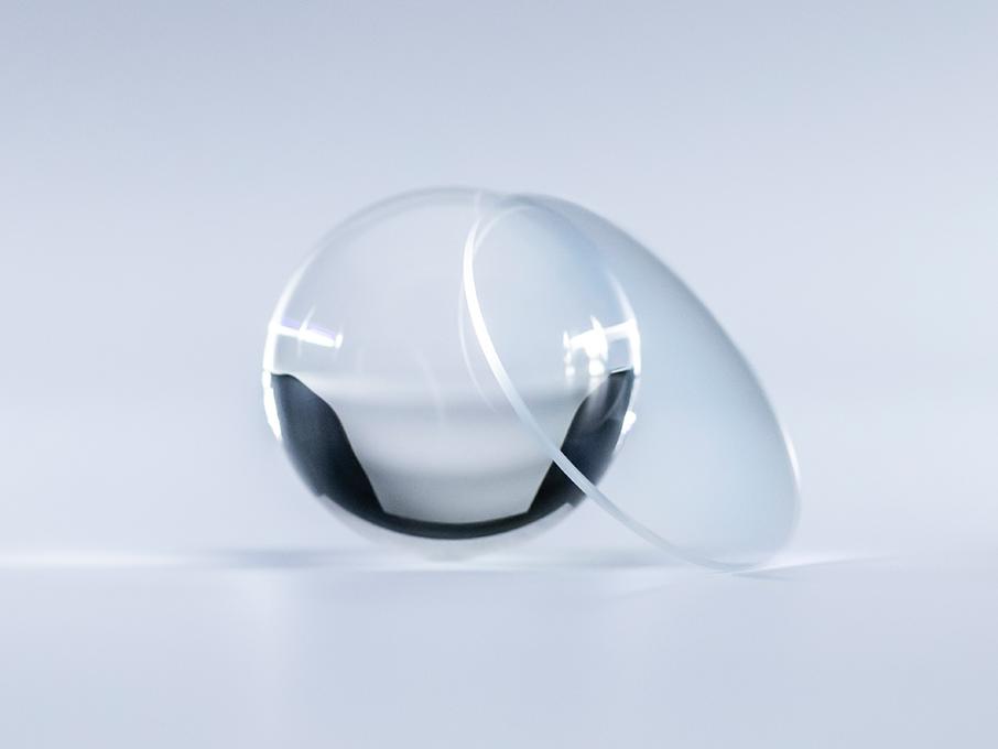 Una lente con trattamento DuraVision Platinum risulta cristallina e priva di riflessi rispetto alla sfera di vetro accanto.