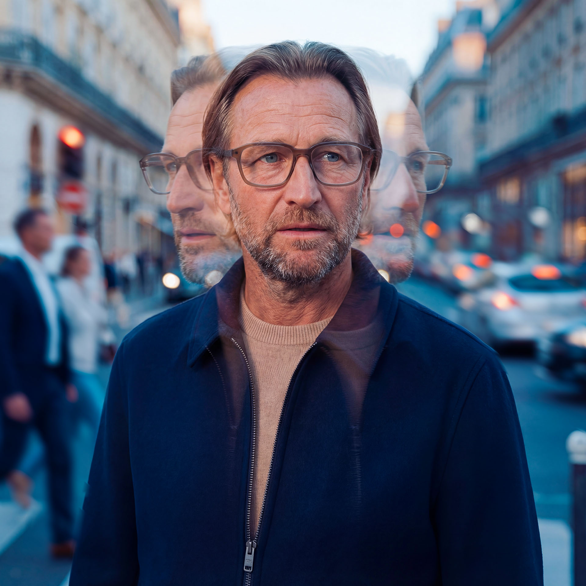 Una persona che indossa occhiali tradizionali in una via trafficata con effetto di esposizione multipla. 