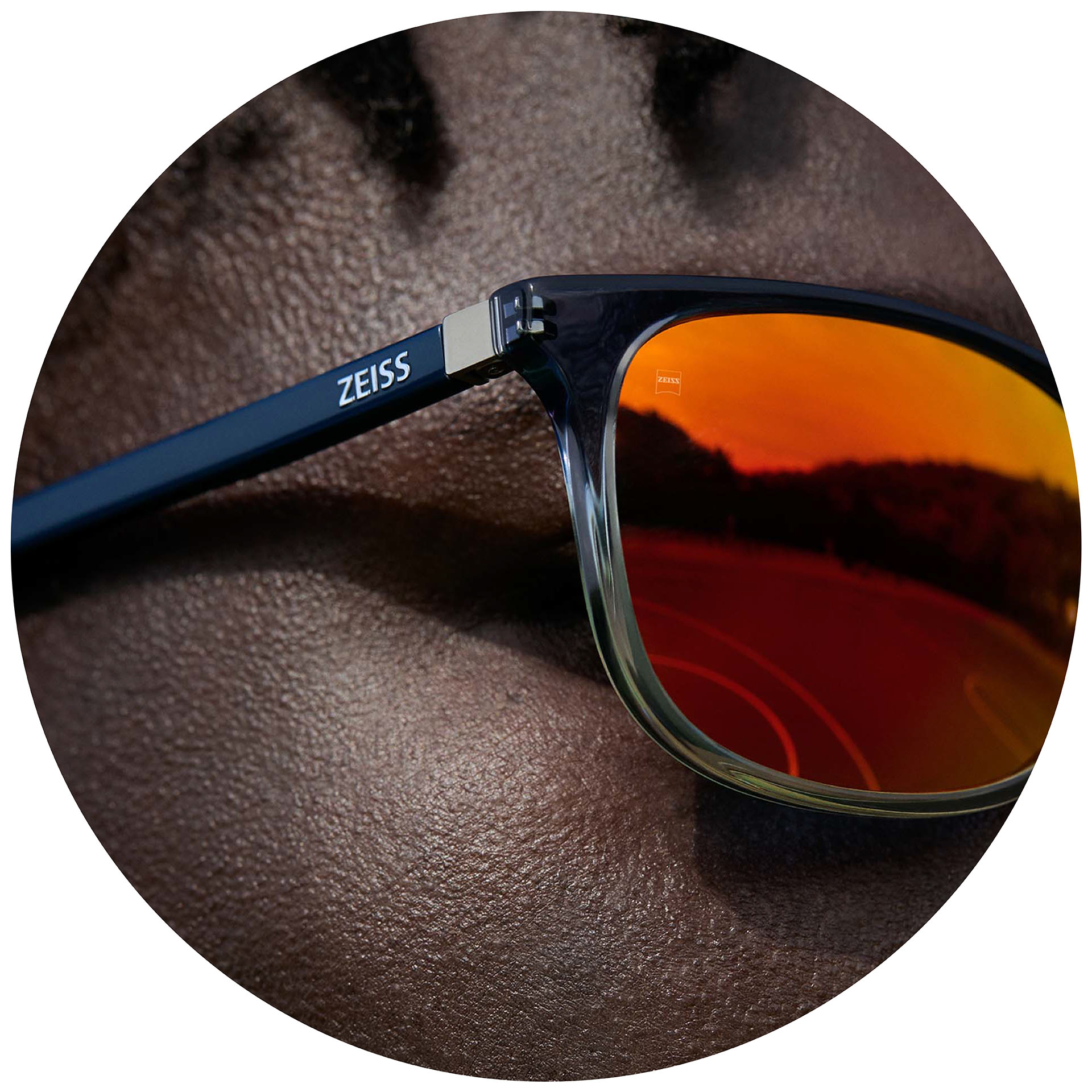 Uomo che indossa ZEISS Eyewear con lenti per occhiali da sole graduati con trattamento a specchio arancione.