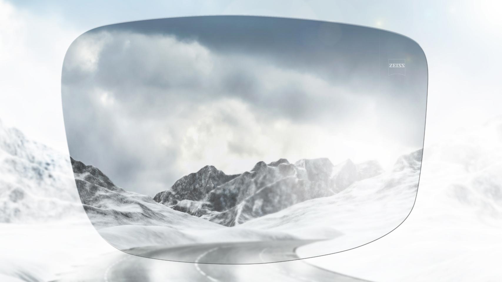 Vista di una strada di montagna innevata con e senza occhiali polarizzati. Gli occhiali da sole polarizzati riducono l&apos;abbagliamento per una visione più nitida.