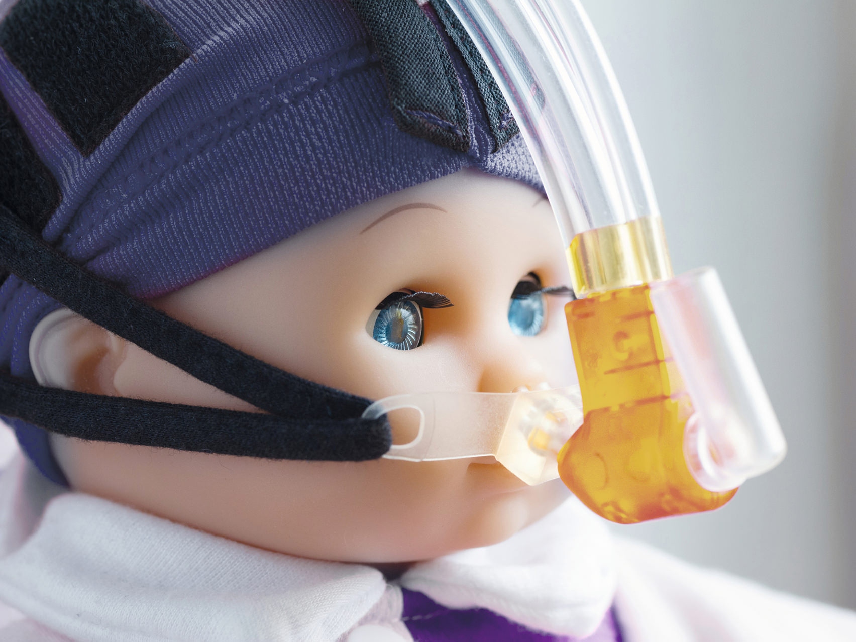 Immagine ravvicinata del viso di una bambola con una maschera respiratoria.