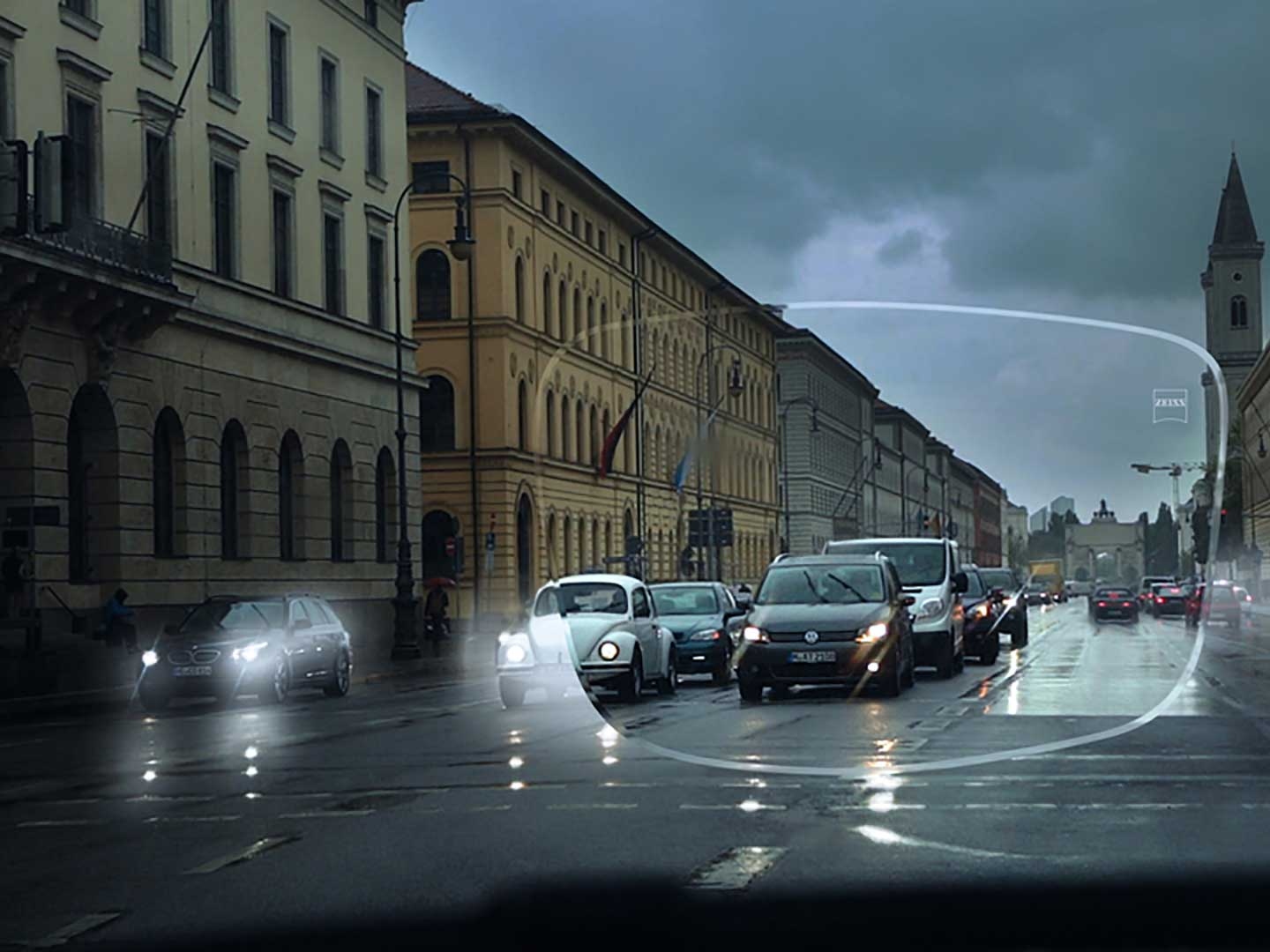 L'immagine mostra i problemi visibilità in condizioni di scarsa illuminazione su una strada. Il punto di vista è l'interno di un'auto visto attraverso le lenti per occhiali. 