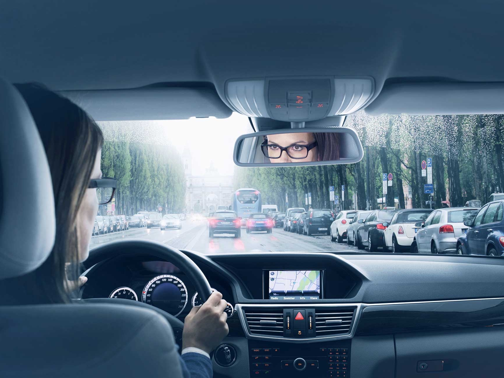 L'immagine dell'interno di un'auto con una donna alla guida. 