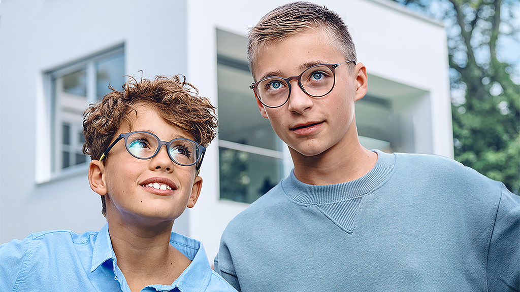 Un bambino che guarda un adolescente. Entrambi portano occhiali ZEISS Single Vision SmartLife Young